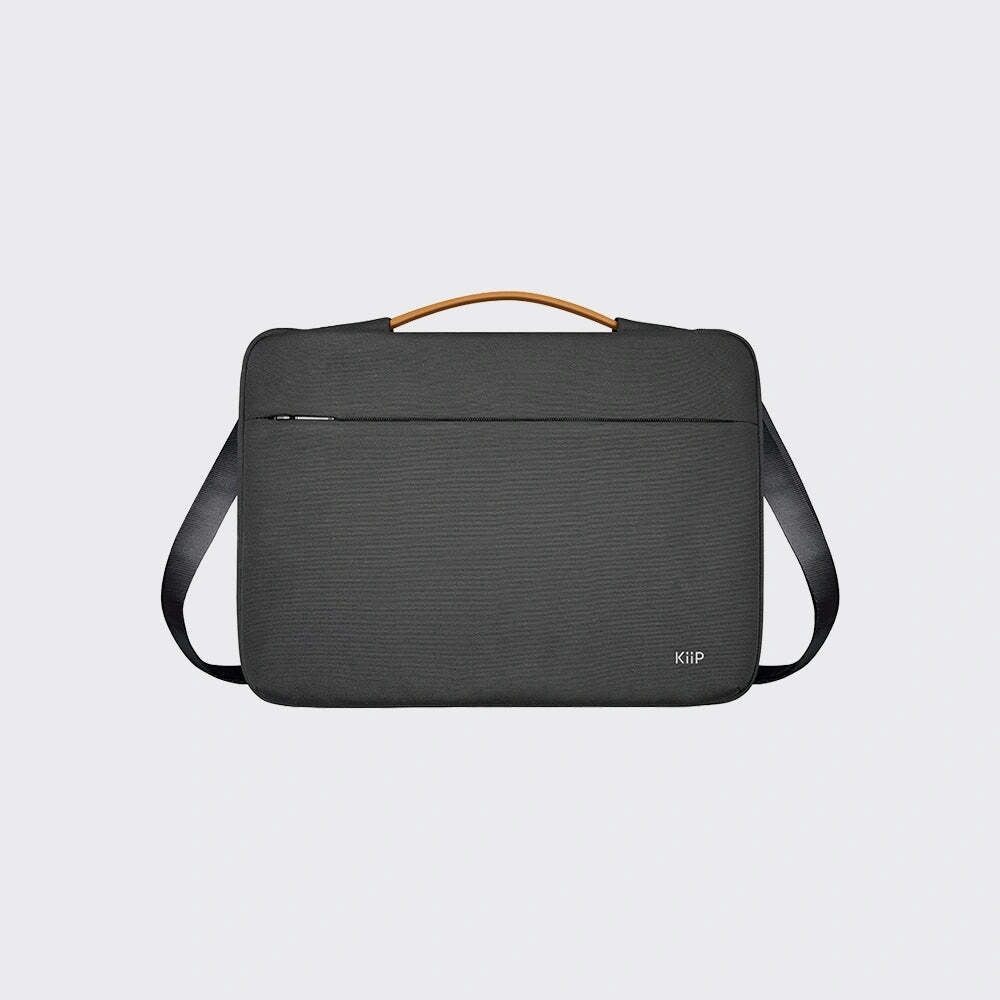 A dark gray textured crossbody laptop bag with a tan leather top handle and a black shoulder strap, shown against a light gray background.