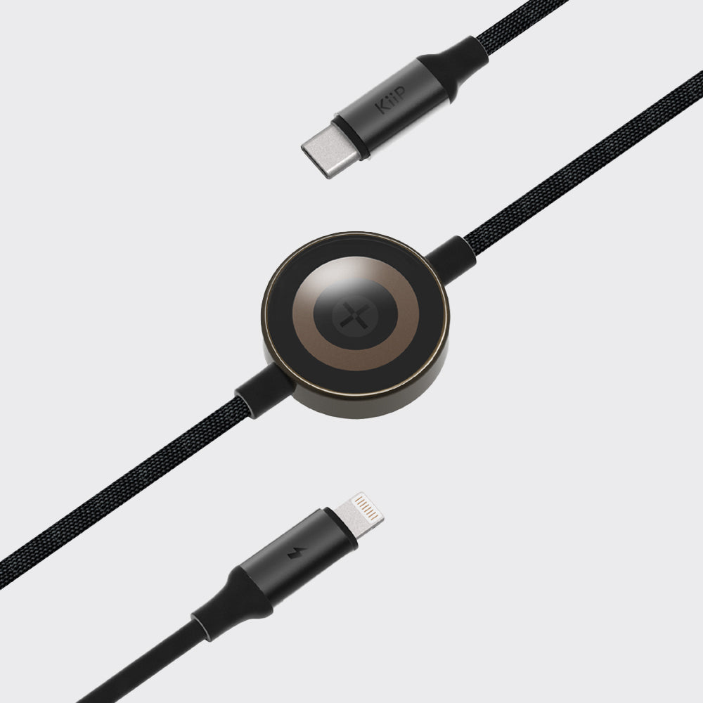 A black braided USB-C to Lightning cable with a central circular wireless charging receiver, shown on a light gray background.