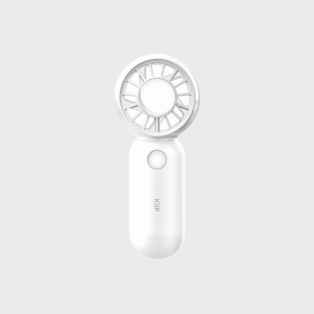 A compact white handheld fan with a circular fan head and a smooth cylindrical handle, shown against a light gray background. The handle features a small circular button and the brand name 'kip' printed vertically.