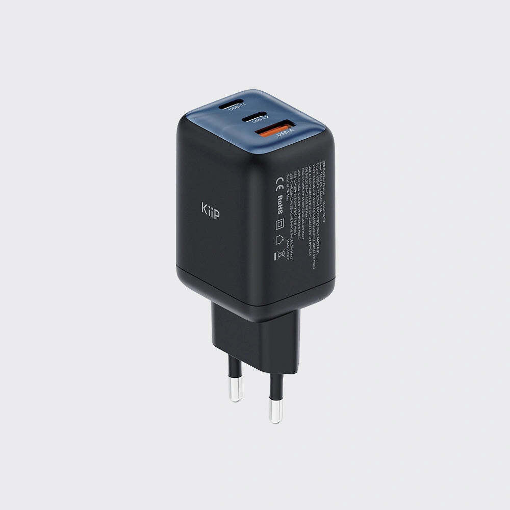 A black Kiip travel charger with a dark blue top panel and two USB-C ports, featuring a European plug, shown on a light gray background.