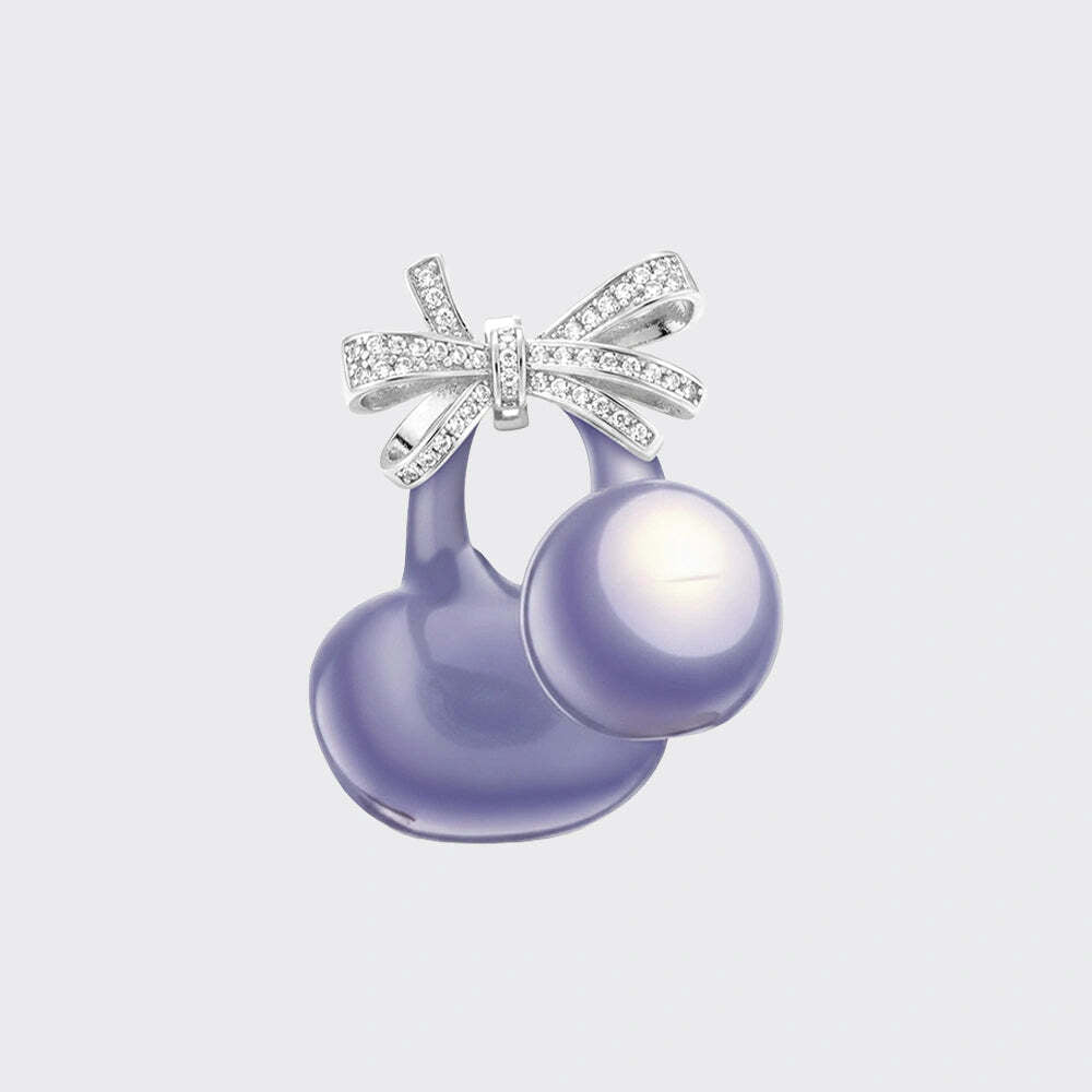 A cherry-shaped pendant featuring a large lavender pearl and a silver bow adorned with clear pavé stones, shown on a light gray background.
