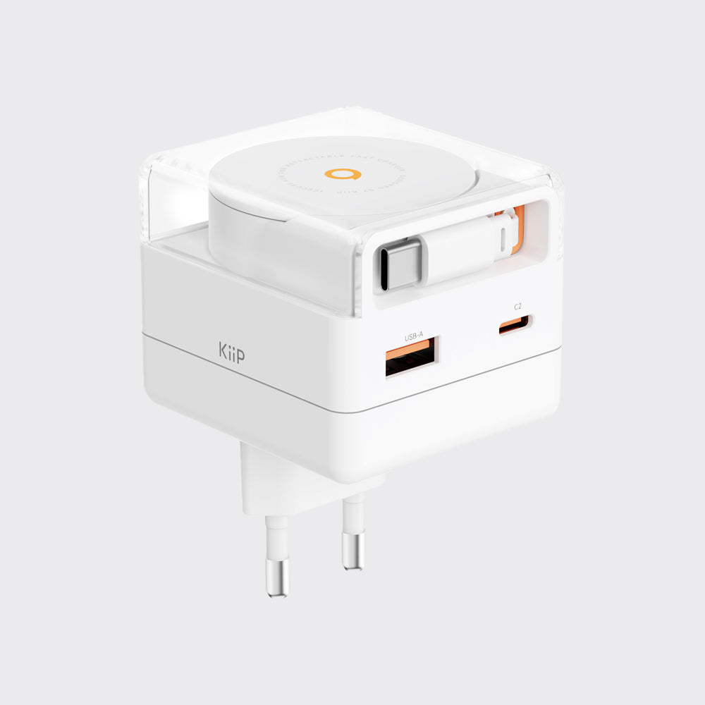 A white KUP travel power adapter with a clear protective cover, featuring a built-in circular wireless charging pad on top, a USB-C port, and a USB-A port on the side, set against a solid light gray background.
