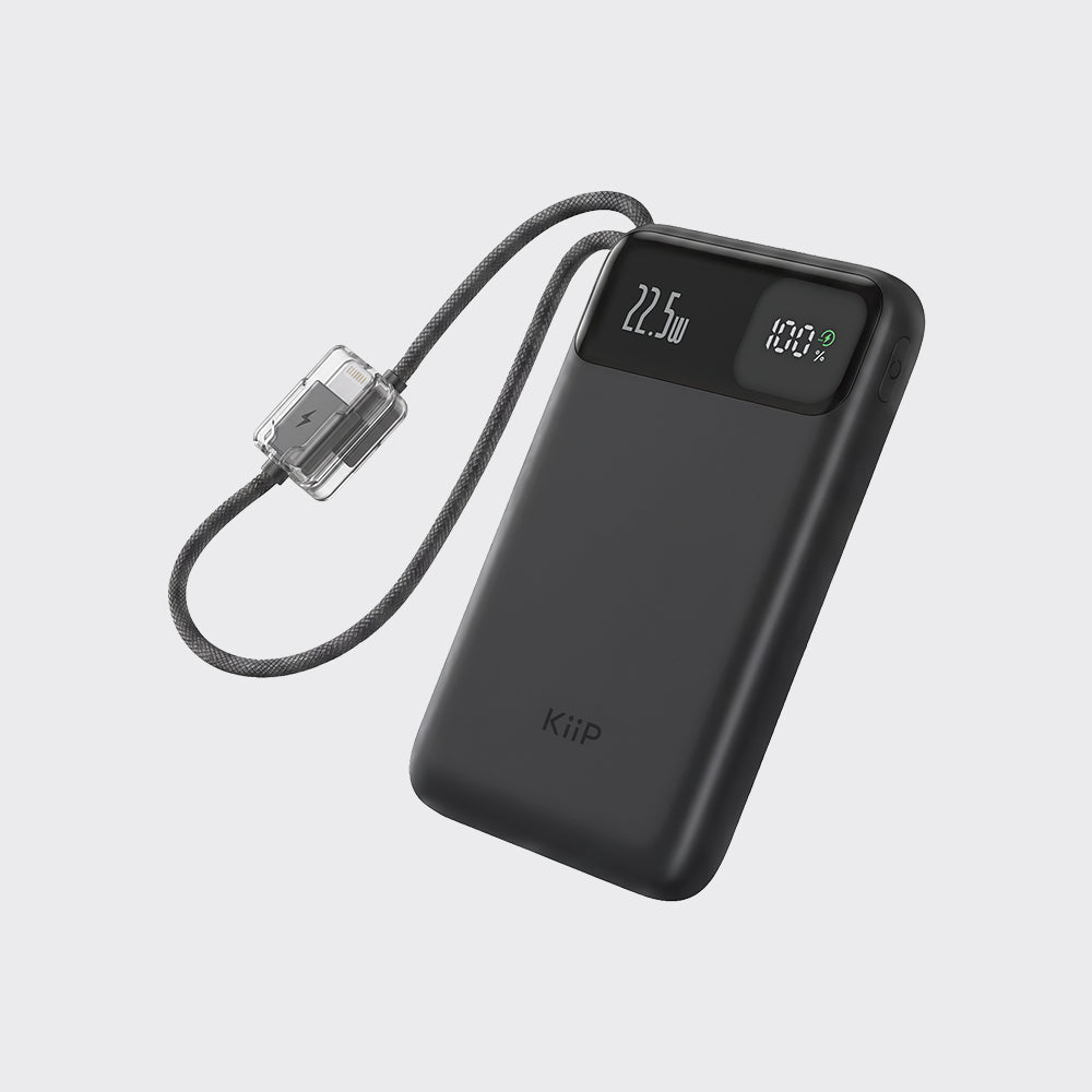 A black KiiP portable power bank with a built-in cable and clear connector, featuring a digital display showing 22.5W and 100% battery level, on a light gray background.